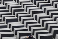 FILE PHOTO: A girl rests on a concrete column of the Holocaust memorial in Berlin