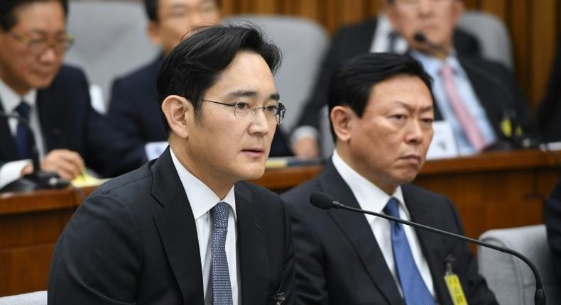 Samsung Group's heir-apparent Lee Jae-Yong (L) answers a question as Lotte Group Chairman Shin Dong-Bin listens during a parliamentary probe into a scandal engulfing President Park Geun-Hye, at the National Assembly in Seoul, on December 6, 2016