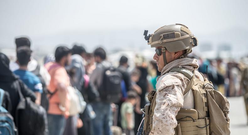 A Marine provides assistance during the evacuation at Hamid Karzai International Airport, in Kabul, Afghanistan, on August 22, 2021.
