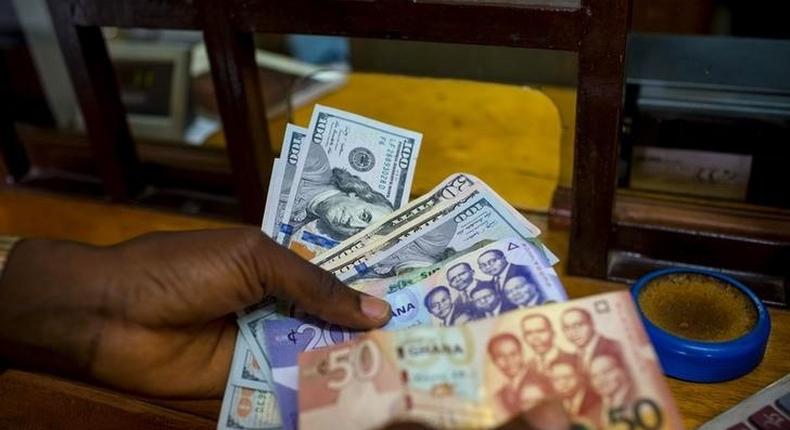 A man trades U.S. dollars for Ghanaian cedis at a currency exchange office in Accra, Ghana, June 15, 2015. Picture taken June 15. REUTERS/Francis Kokoroko