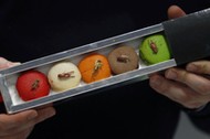 A man holds up a pack of macaroons containing dehydrated insects at the Micronutris plant in Saint O