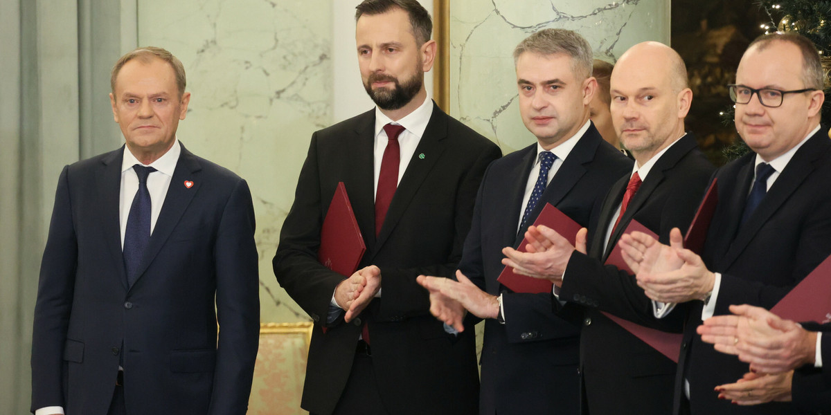 Premier Donald Tusk i nowi ministrowie podczas zaprzysiężenia w Pałacu Prezydenckim.