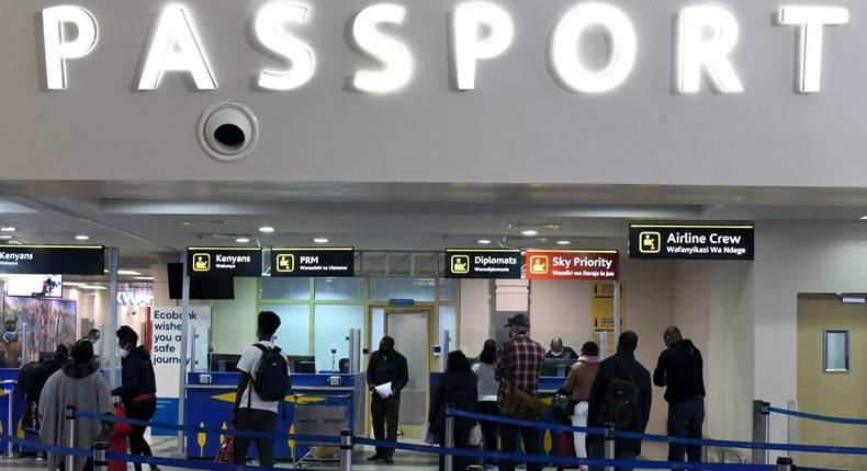 Passengers, wearing protective face masks, queue at passport control desks at the Jomo Kenyatta international airport in Nairobi, on August 1, 2020, as Kenya Airways airline resumed flights to Britain after flights had been cancelled during the COVID-19 (novel coronavirus) pandemic outbreak. (Photo by SIMON MAINA/AFP via Getty Images)