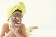 Portrait of a girl with a face mask and towel turban on her head