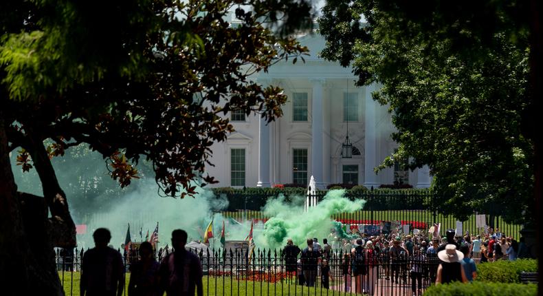 A protester releases green smoke during an abortion-rights rally in Lafayette park in front of the White House in Washington, Monday, July 4, 2022. (AP Photo/Andrew Harnik)