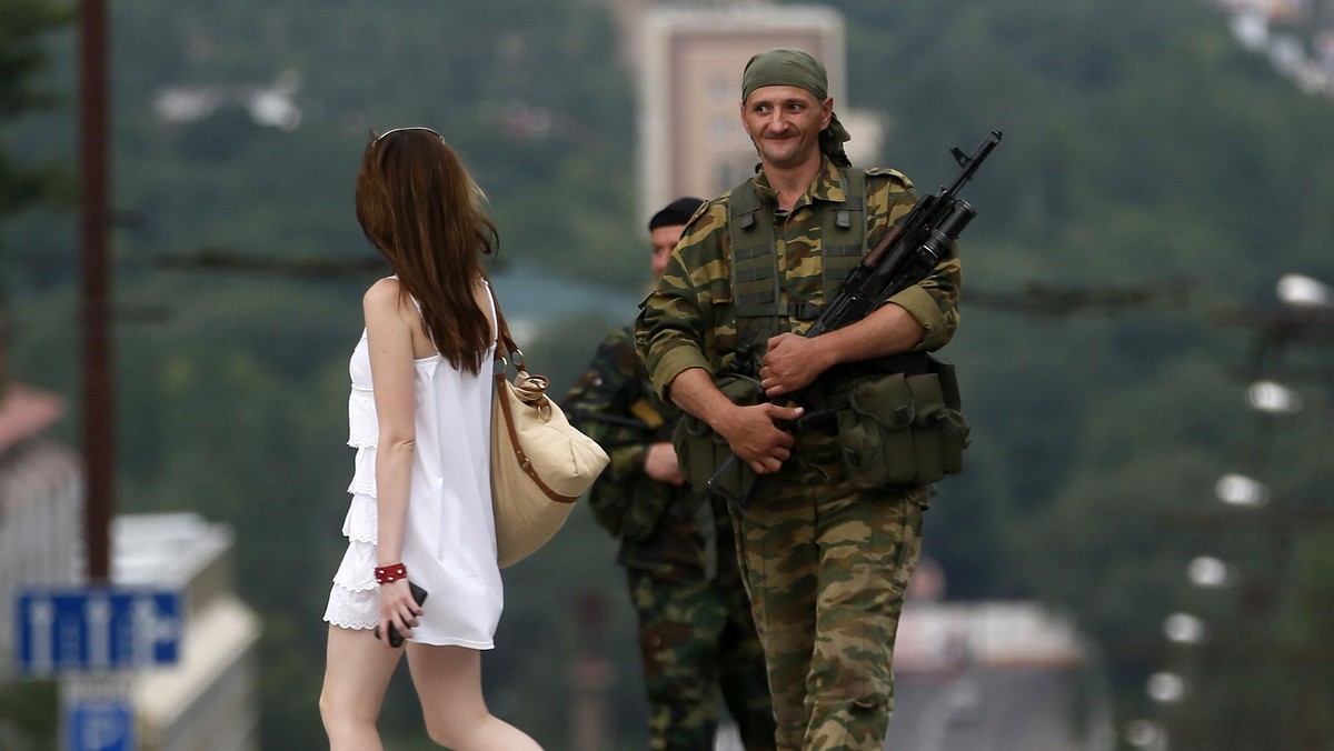 An armed man smiles at a girl