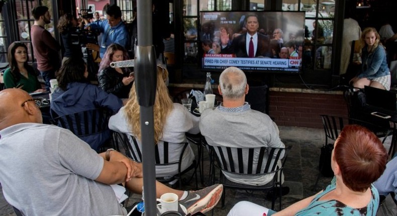 Patrons at Shaw's Tavern watch as former Federal Bureau of Investigation Director James Comey is sworn in to testify before the Senate Intelligence Committee on June 8, 2017