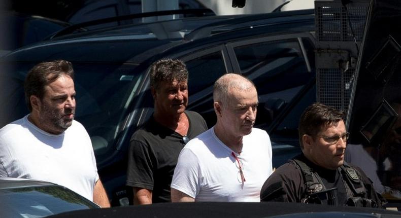 Brazilian businessman Eike Batista (2-R) is escorted as he leaves the Federal Police headquarters after a hearing in Rio de Janeiro, Brazil on February 8, 2017