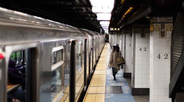 A koronavírus-járvány miatt védőmaszkot viselő nő száll ki a metrókocsiból a New York-i Grand Central Terminal fejpályaudvarnál 2020. december 7-én. A New Yorki-i közlekedési hatóság (MTA) komoly veszteségekre számít, mivel a koronavírus-járvány miatt jelentősen csökkent az utasok száma / Fotó: MTI/EPA/Justin Lane