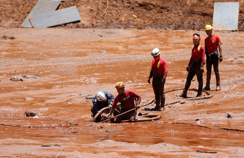 Members of a rescue team carry a body recovered after a tailings dam owned by Brazilian mining compa