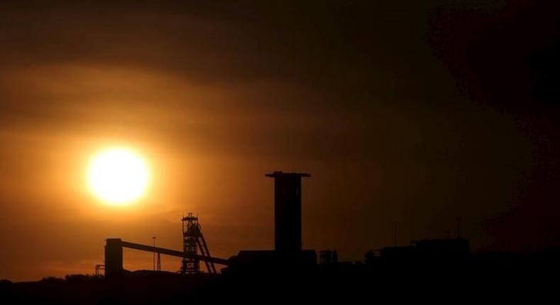 The sun sets behind a shaft outside the mining town of Carletonville, west of Johannesburg, July 7 2015. 