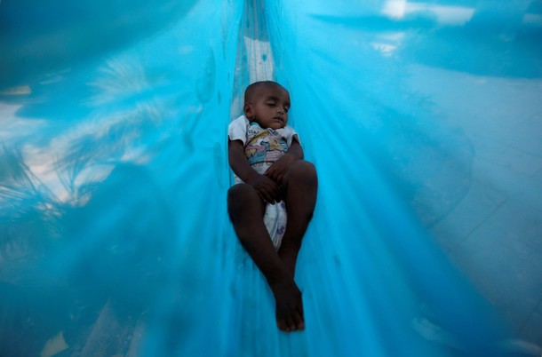 Eleven-month-old Sakeena sleeps in a hammock on the promenade next to a lake in Mumbai