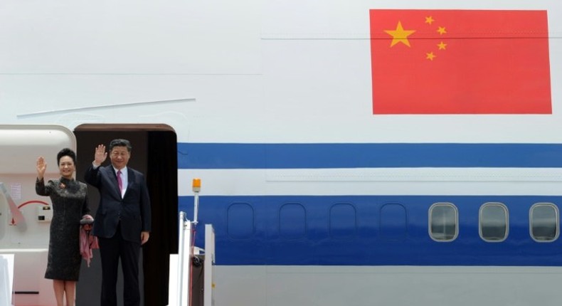 China's President Xi Jinping and his wife Peng Liyuan wave as they depart from Hong Kong's international airport, on July 1, 2017