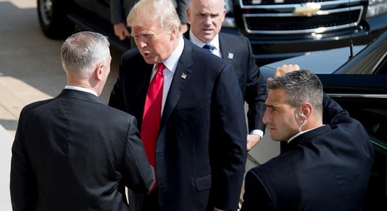 US President Donald Trump (C) shakes hands with US Defense Secretary James Mattis (L) as he arrives at the Pentagon in Washington for a strategy session on defeating IS