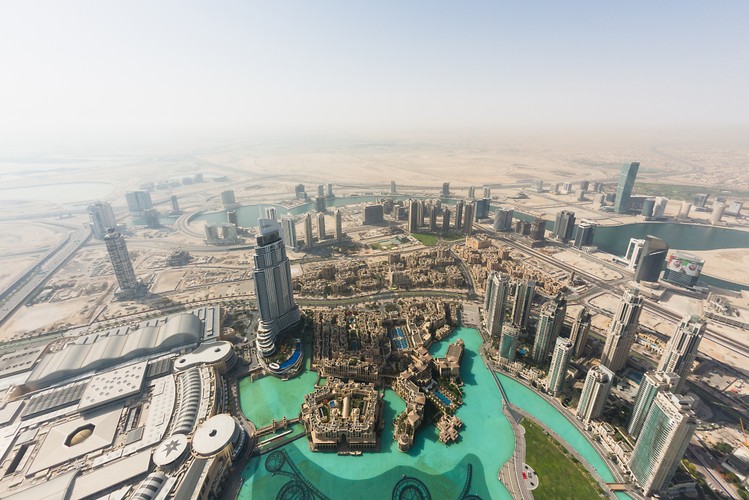 Widok na Dubaj z górnych pięter Burj Khalifa, najwyższego wieżowca na świecie. Wokół biznesowej dzielnicy Dubaju rozciągają się niezagospodarowane obszary pustyni, które niebawem mają stać się nowym centrum handlu. We wrześniu 2012 roku szejk  Mohammed bin Rashid Al Maktoum ogłosił, że zamierza stworzyć w Dubaju nowy rodzaj miasta w mieście – tzw. Mohammed Bin Rashid City. Największy deweloper w Zjednoczonych Emiratach Arabskich, Emaar Properties PJSC, ma wybudować  tu największe centrum handlowe na świecie wraz z wielkim kompleksem hoteli i ogrodów. Powstaną tu także tereny przeznaczone pod budownictwo mieszkaniowe. Fot. Duncan Chard, Bloomberg's Best Photos 2013.