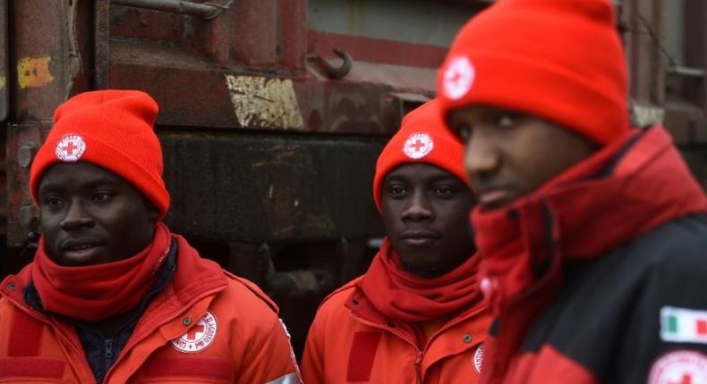 A group of migrants who volunteer with the Italian Red Cross stand at the Penna emergency operations center, 20 km from avalanche site that engulfed Hotel Rigopiano, in central Italy, on January 21, 2017