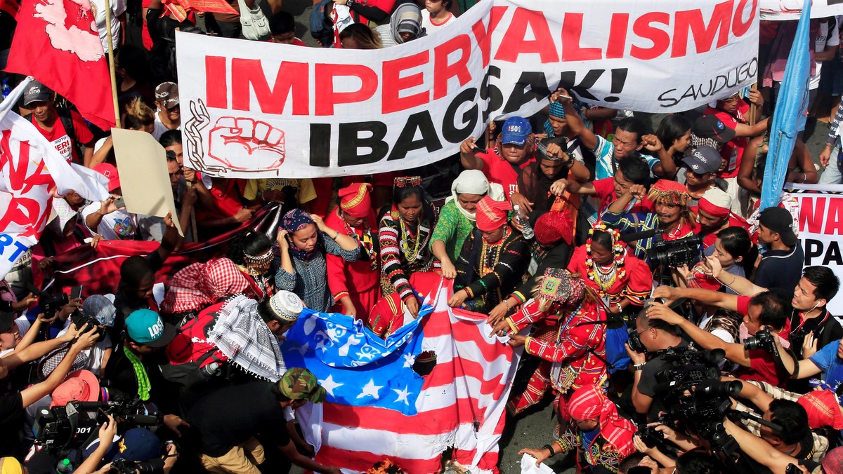 Various activists and Indigenous People's group burn a mock U.S. flag as they hold a rally supporting President Rodrigo Duterte's independent foreign policy in metro Manila