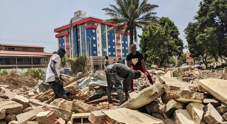 Des hommes récupèrent des métaux sur le chantier de démolition de la cité ministérielle à Conakry. © Matthias Raynal/RFI