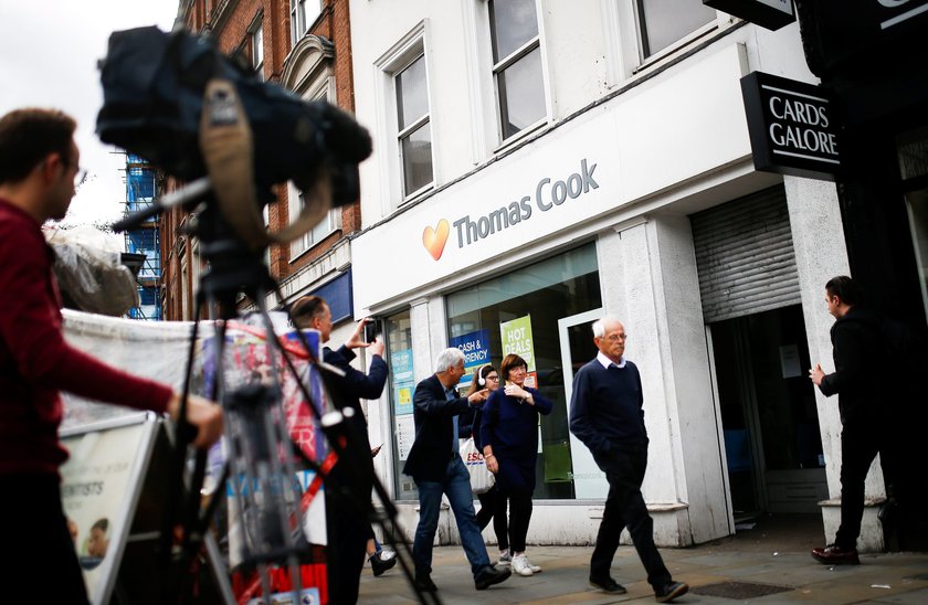 A television crew film outside of a closed Thomas Cook store in London