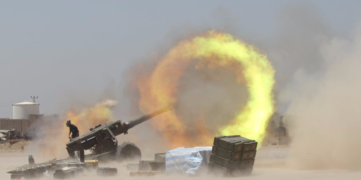 An Iraqi Shi'ite fighter firing artillery during clashes with Islamic State militants near Fallujah, Iraq.