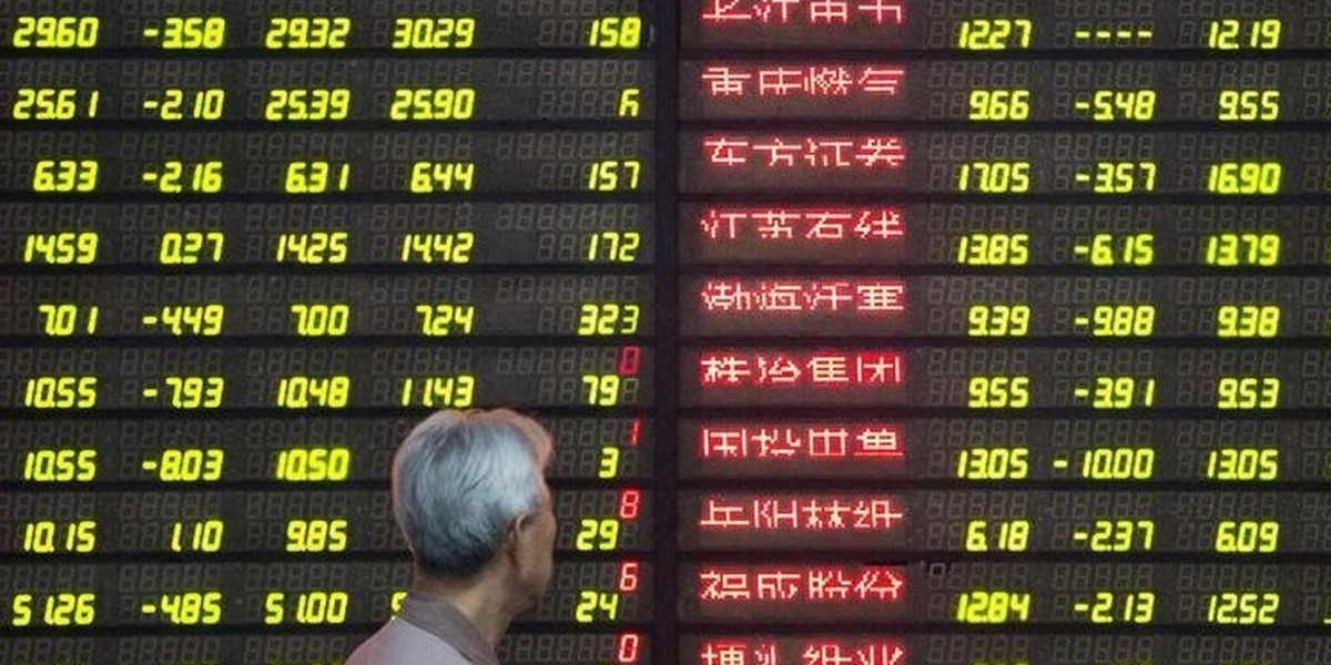 An investor looks at an electronic screen showing stock information at a brokerage house in Nanjing