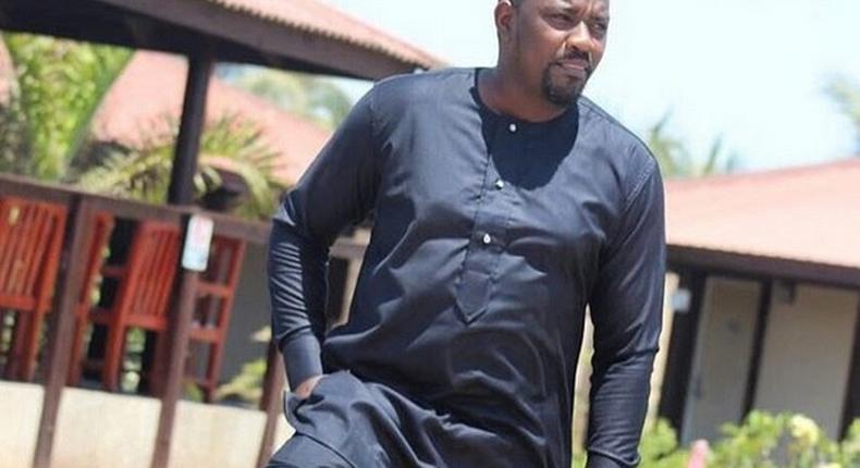 John Dumelo standing by a pool