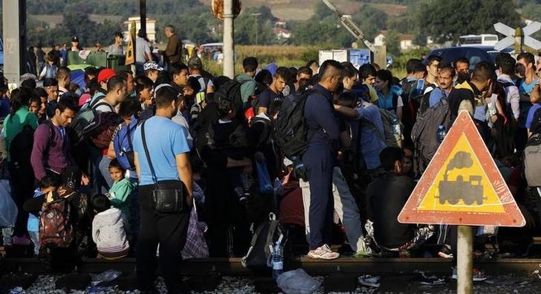 Syrian refugees gather along the train tracks as they arrive at Greece's border with Macedonia near the Greek village of Idomeni, September 11, 2015.   REUTERS/Yannis Behrakis