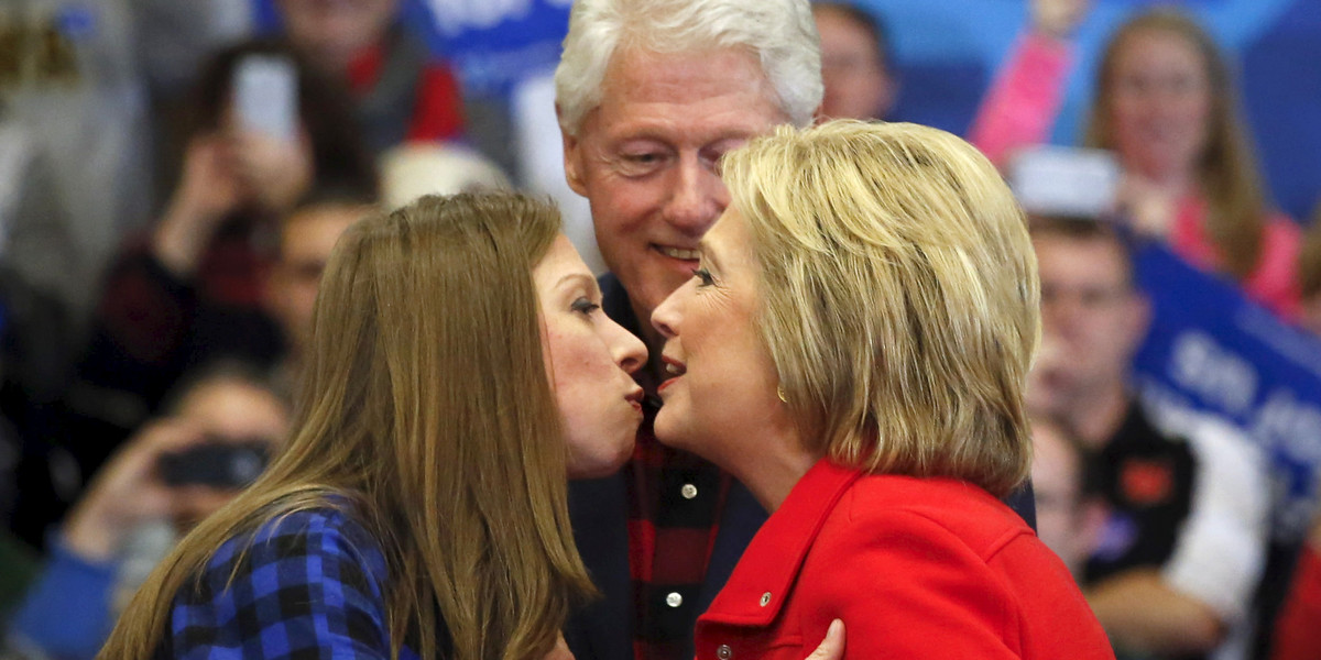 U.S. Democratic presidential candidate Hillary Clinton (R) kisses her daughter Chelsea Clinton (L) as former U.S. President Bill Clinton is seen in the background during a campaign rally at Washington High School in Cedar Rapids, Iowa January 30, 2016.