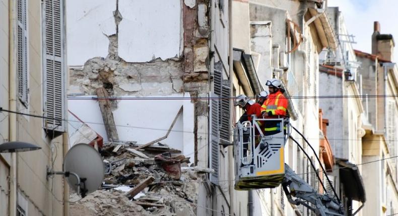 Firemen inspecting buildings near the site where two dilapidated buildings suddenly collapsed this week in the centre of Marseille, southern France