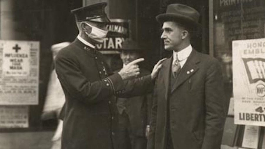 Policjant w masce poucza mieszkańca o obowiązku noszenia maseczek, San Francisco 1918 roku