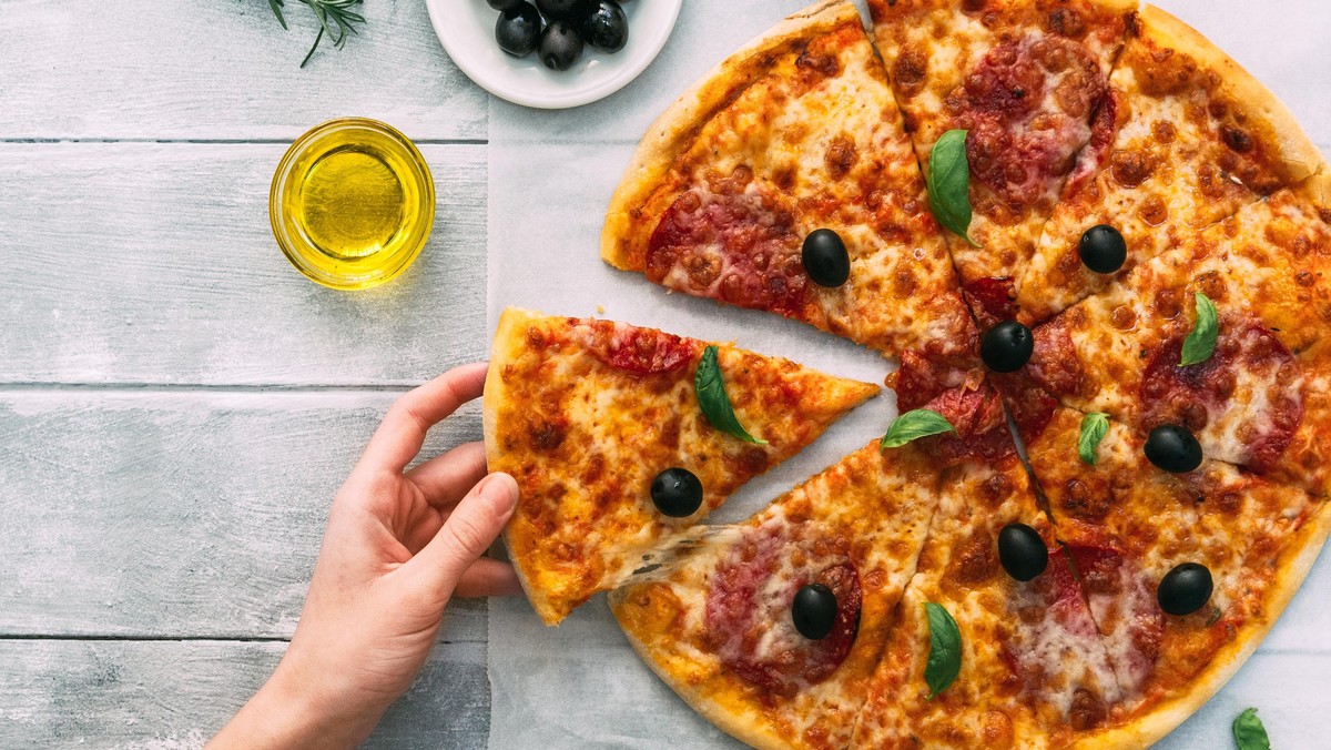 colorful tasty pizza. woman taking piece of italian pizza