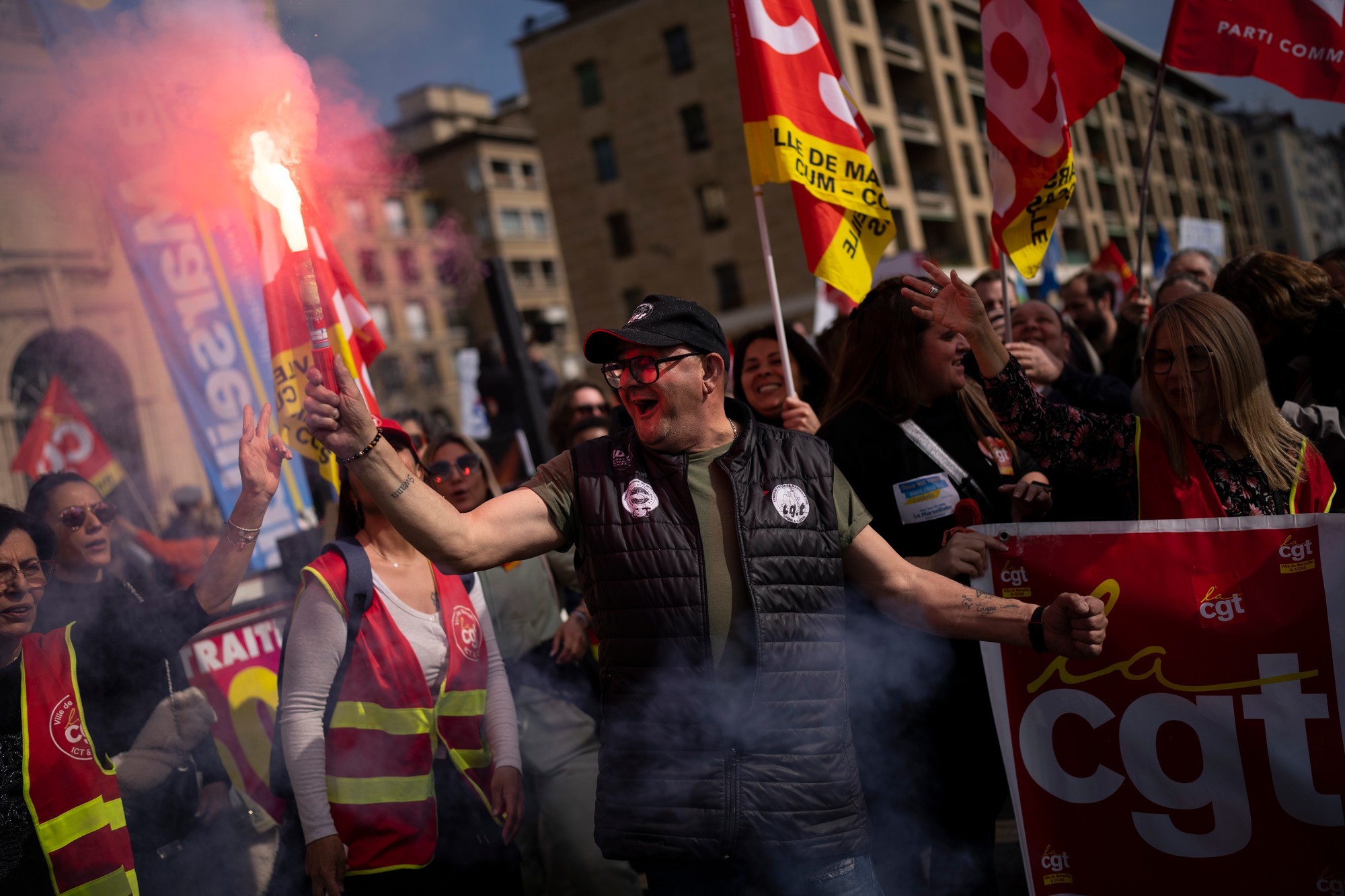 Protestujúci drží svetlicu počas demonštrácie v utorok 7. marca 2023 v Marseille.
