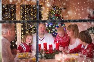 Family enjoying Christmas dinner at home in decorated room