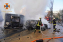 Strażacy dogaszają samochody po ataku rakietowym w centrum Kijowa