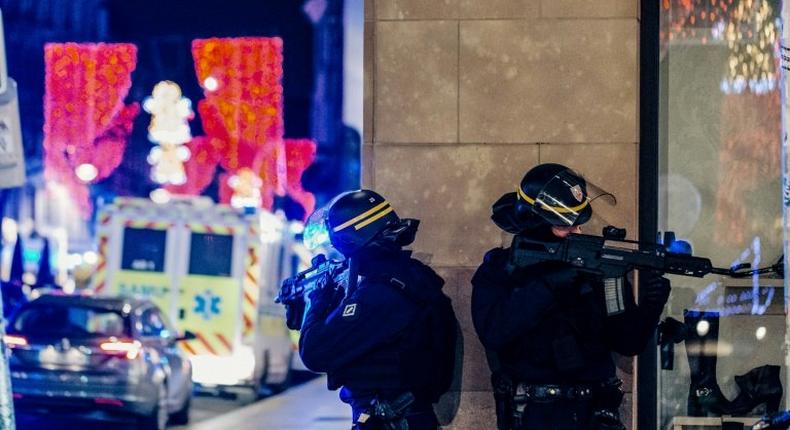 Police officers stand guard near the scene of a shooting in the French city of Strasbourg that has prompted President Donald Trump to renew calls for a wall along the US-Mexico border