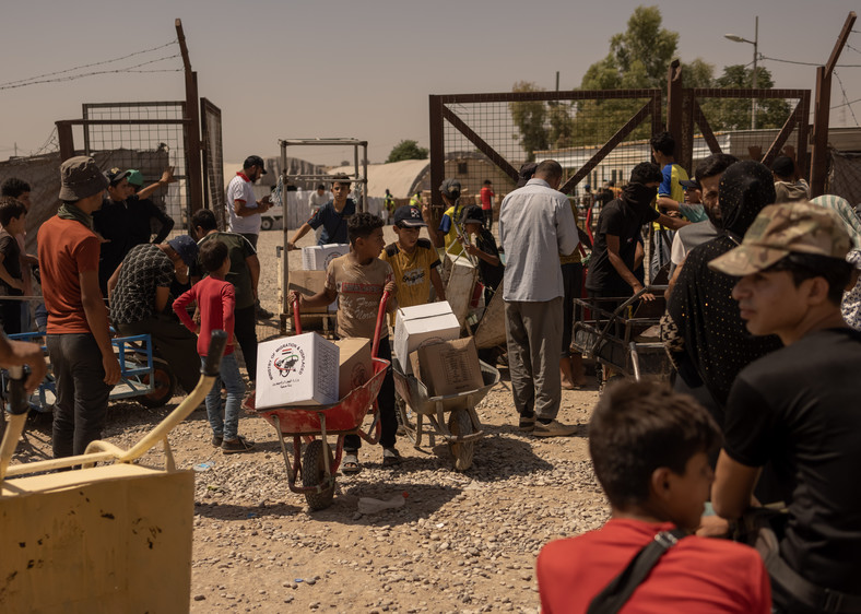 Dzieci odbierające paczki żywnościowe w Hassan Sham