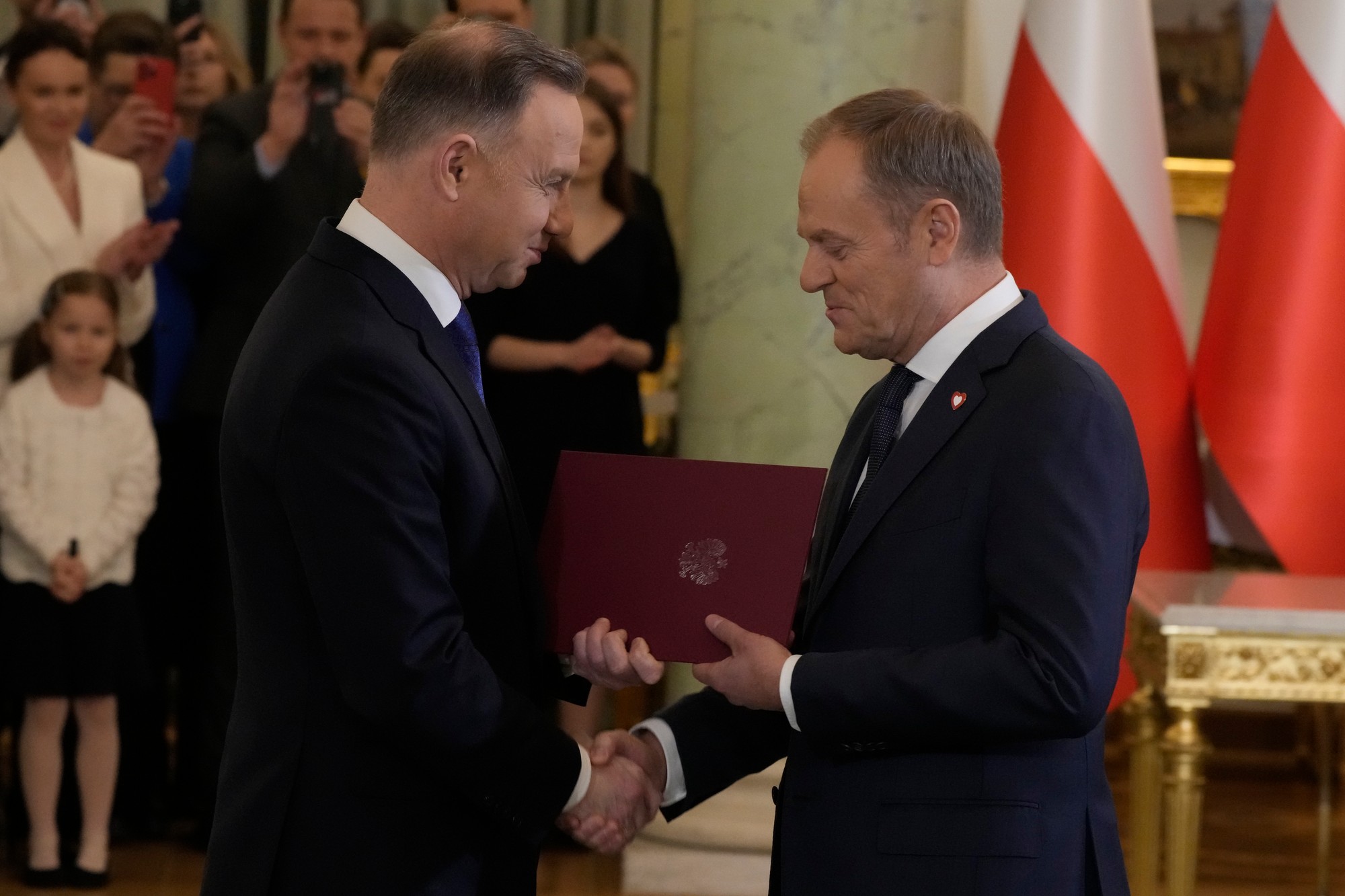 Poľský prezident Andrzej Duda (vľavo) si podáva ruku s poľským premiérom Donaldom Tuskom.