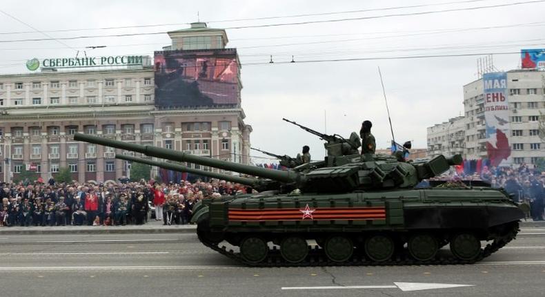 People watch as pro-Russian rebels parade tanks through the center of Donetsk during a WWII Victory Day parade, on May 9, 2017