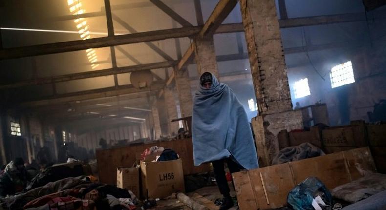 A migrant walks trough a makeshift shelter at an abandoned warehouse in Belgrade, Serbia, on December 8, 2016