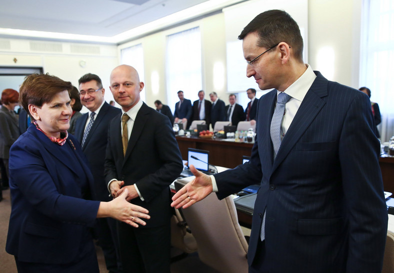 Premier Beata Szydło wita się z wicepremierem Mateuszem Morawieckim. W tle Paweł Szałamacha