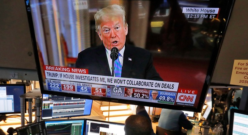 Traders on the floor of the New York Stock Exchange watching President Donald Trump's Wednesday news conference.