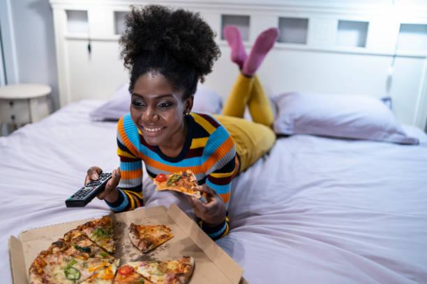 Photo of woman eating in bed