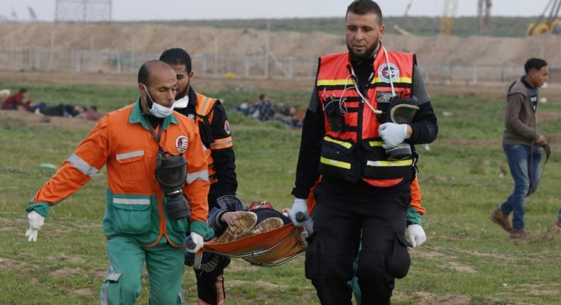 Palestinian paramedics evacuate a protester near the fence separating the Gaza Strip from Israel, east of Gaza City, on February 1, 2019