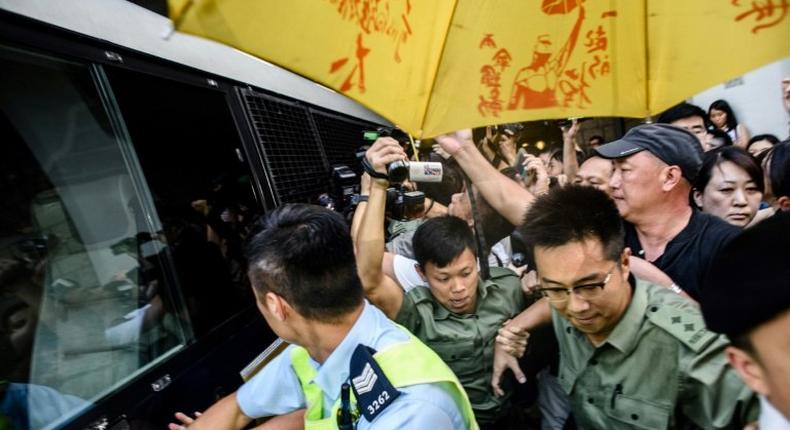 Police and supporters surround a prison van transporting Joshua Wong after his sentencing