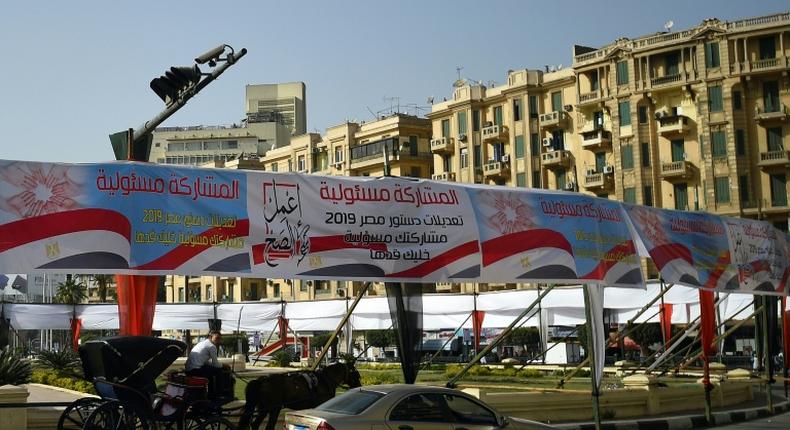 Egyptians pass under banners reading in Arabic Do what is right and Participation is your responsibility, urging voters to vote in the referendum on constitutional amendments