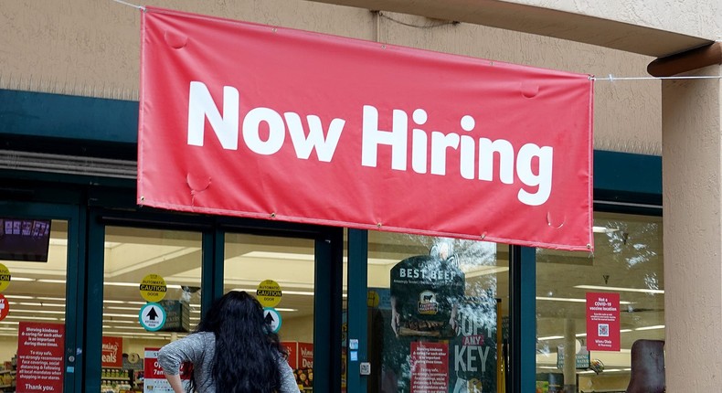 A Now Hiring sign hangs near the entrance to a Winn-Dixie Supermarket on September 21, 2021 in Hallandale, Florida.