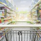 Supermarket aisle with empty green shopping cart