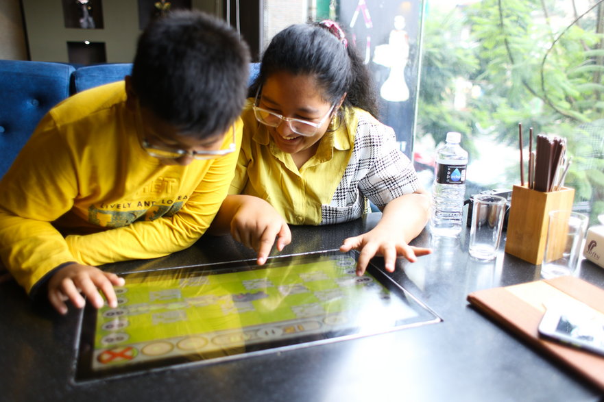 Ludzie wybierający dania z cyfrowego menu w restauracji Naulo. To pierwsza w Nepalu w pełni zdigitalizowana restauracja robotyczna, obsługiwana przez kelnerów-robotów