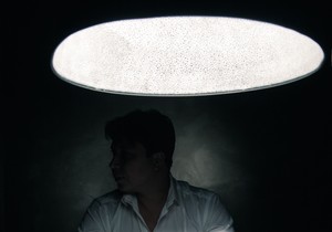 stock-photo-man-in-a-dark-room-illuminated-only-by-a-light-coming-from-a-lamp-no-face-seen-250644610