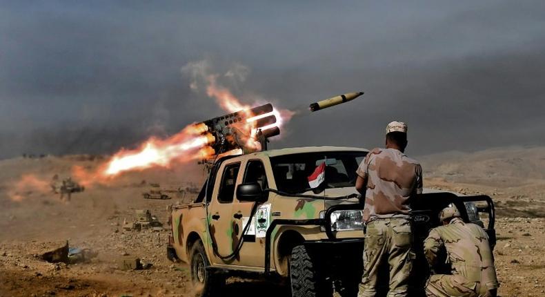 Soldiers from the Iraqi army's 9th Division fire a multiple rocket launcher from a hill in Talul al-Atshana, on the southwestern outskirts of Mosul